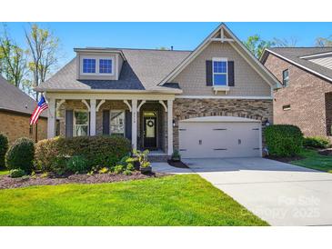 Charming home featuring a stone facade, attached garage, well-manicured lawn, and a welcoming front porch at 2119 Augusta National Dr, Denver, NC 28037