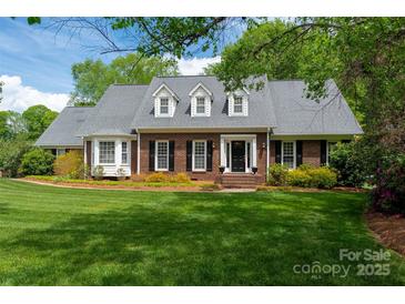 Charming brick home boasts a lush, green lawn and well-maintained landscaping under a bright, sunny sky at 2382 Erika Ln, Gastonia, NC 28056