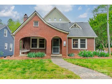 Charming brick home with a cozy front porch swing and professionally landscaped front yard at 2400 Commonwealth Ave, Charlotte, NC 28205