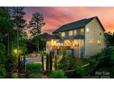 An elegant backyard featuring a pool, covered patio, and lush landscaping, ideal for entertaining at 288 Ridge Reserve Dr, Lake Wylie, SC 29710