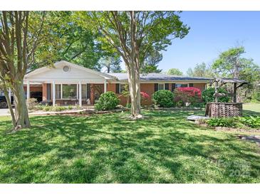 Charming brick home with a well-manicured lawn, a cozy porch, and mature trees creating a welcoming curb appeal at 3265 W Innes St, Salisbury, NC 28144