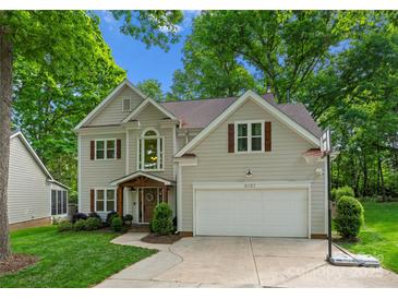 Charming two-story home with attached garage and landscaped front yard is surrounded by mature trees at 6101 Park Hill Rd, Charlotte, NC 28277