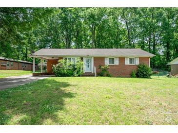 Charming brick home with a well-manicured lawn and inviting front entrance with carport at 907 E 9Th Ave, Gastonia, NC 28054