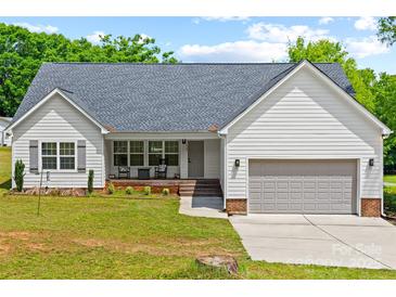 Charming single Gathering home with a well manicured front lawn, driveway, and integrated garage at 1009 Rainbow Cir, Catawba, SC 29704