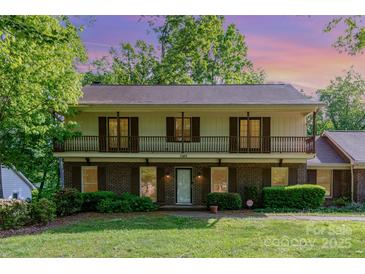 Charming two-story home with brick facade, large front yard, and covered second-story balcony at 1340 Piccadilly Dr, Charlotte, NC 28211