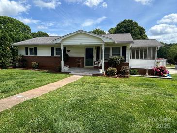 Charming single story home with a brick foundation, cozy porch swing, and a well-manicured lawn at 201 Mitchell St, Belmont, NC 28012
