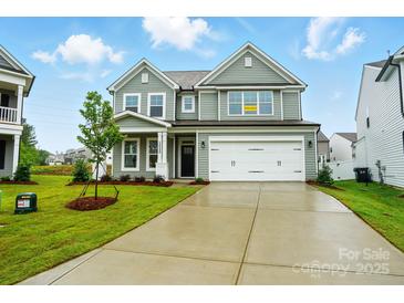 Charming two-story home featuring a two-car garage, manicured lawn, and classic architectural details at 2020 Embassy Ct # 48, Charlotte, NC 28213