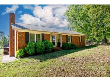 Charming single story red brick home featuring mature trees, shutters, and an inviting front entrance at 3842 Harmony Rd, Catawba, SC 29704