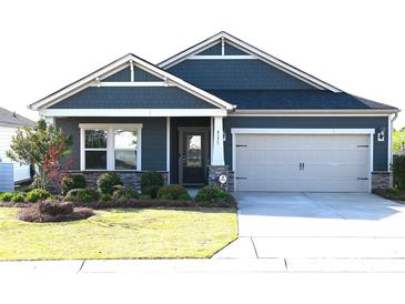Charming one story home with blue siding, stone accents, manicured lawn, and attached two car garage at 4171 Canopy Creek Dr, Denver, NC 28037