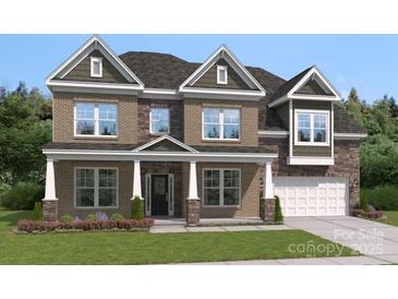 Charming two-story home featuring a brick facade, covered entrance, and well-manicured lawn at 424 Balboa St, Matthews, NC 28104