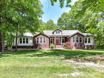 Charming brick and siding home with a well-manicured lawn and lush landscaping on a sunny day at 4301 Middle Stream Rd, Charlotte, NC 28213