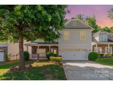 Charming two-story home features a two-car garage, covered front porch, and mature landscaping at 5106 Stone Park Dr, Charlotte, NC 28269