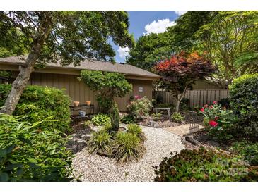 Landscaped garden featuring a stone bench, flowers, and decorative gravel, offering a peaceful outdoor retreat at 5128 Dunes Ct, Charlotte, NC 28226