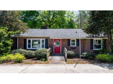 Charming brick home with a red door, set in a well-maintained yard with lush green bushes at 536 Hartness Rd, Statesville, NC 28677