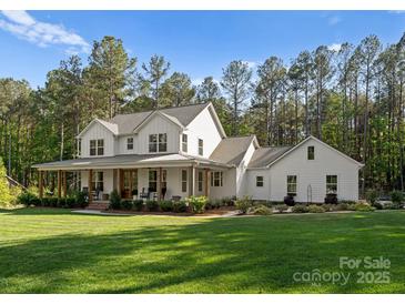 Charming two-story white farmhouse with a spacious front yard and inviting porch at 7351 Bay Cove Ct, Denver, NC 28037