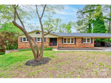 Charming brick home with a manicured lawn, mature trees, and an attached carport at 910 Surry Dr, Shelby, NC 28152