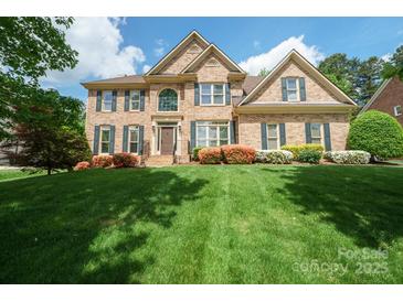Beautiful two-story brick home with a well-manicured lawn, mature landscaping, and a welcoming front entrance at 10101 Bayart Way, Huntersville, NC 28078