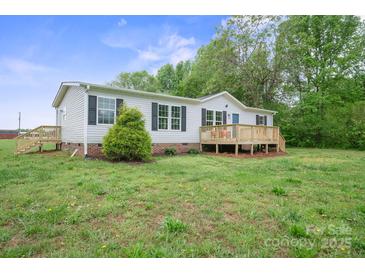 Charming single-story home with a wooden deck and lush green lawn at 125 Rocky Pt, Cleveland, NC 27013