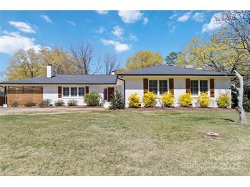 Charming home featuring well-manicured lawn, complemented by colorful shrubs and classic shutters against a bright, sunny sky at 1467 Alexander Rd, Rock Hill, SC 29732