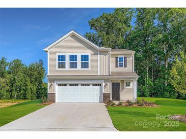 Two story home with beige siding, attached garage, and well-manicured lawn at 2107 Columbidae Ln, Gastonia, NC 28052