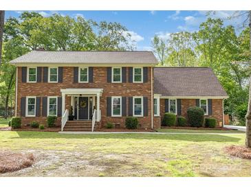 Charming two-story brick home with a well-maintained front lawn and mature trees in a desirable neighborhood at 2514 King Arthur Dr, Monroe, NC 28110