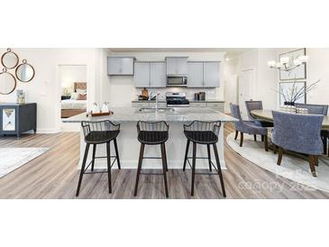 An open kitchen features granite countertops, grey cabinets, a large island, and stainless steel appliances at 4208 Steel Way, Sherrills Ford, NC 28673