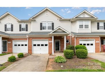 Inviting townhome with brick accents, white siding, manicured landscaping, and attached garages at 5310 Waverly Lynn Ln, Charlotte, NC 28269