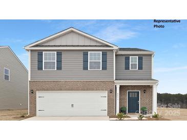 Two-story home featuring a brick and gray siding facade, complemented by a two-car garage and blue window shutters at 870 Two Brothers Ln, York, SC 29745