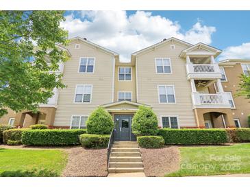 Attractive multi-story condo building featuring private balconies, well-maintained landscaping, and a welcoming entrance at 9027 Mcdowell Creek Ln, Cornelius, NC 28031