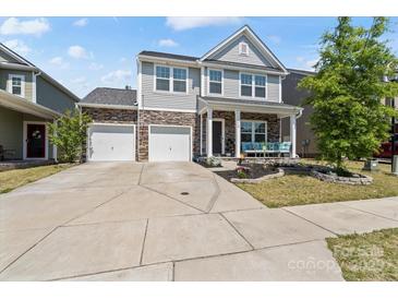 Charming two-story home with stone accents, a well-manicured lawn, and a spacious two-car driveway at 980 Bunker Trce, Rock Hill, SC 29730