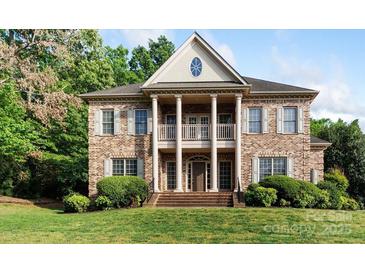 Stately brick home featuring a columned porch and landscaped front yard at 10836 Fox Hedge Rd, Matthews, NC 28105