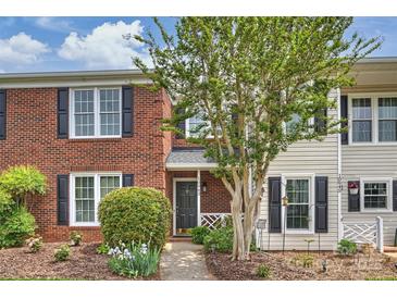 Charming brick townhome featuring a landscaped front yard and a welcoming entrance at 10943 Winterbourne Ct, Charlotte, NC 28277