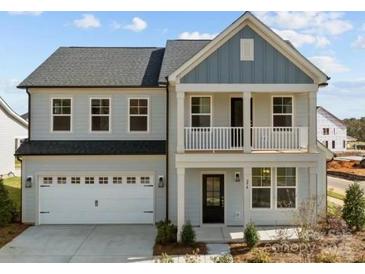 Charming two-story home featuring a covered porch, attached garage, and manicured landscaping at 110 Canary Ln # 3, Mooresville, NC 28115