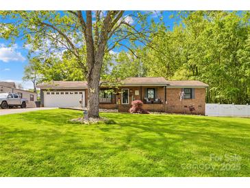Charming brick home with a manicured lawn, mature shade tree, and an attached two-car garage at 1279 Rocky Creek Rd, Shelby, NC 28152