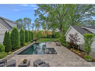 Inviting in-ground pool with patio seating and lush landscaping provides a private outdoor retreat at 309 Catawba Ave, Davidson, NC 28036