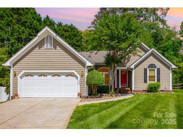 Charming home featuring a two-car garage, well-manicured lawn, and welcoming red front door at 3200 Tallia Ct, Charlotte, NC 28269