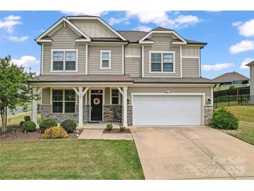 Charming two-story home featuring a covered porch, attached two-car garage, and landscaped front yard at 341 Pleasant Hill Se Dr, Concord, NC 28025