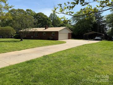 Charming brick home features a long driveway and a spacious, well-manicured front yard at 370 Sherrill Farm Rd, Lincolnton, NC 28092