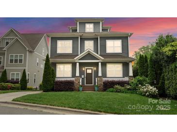 Charming two-story home with a landscaped yard and inviting front porch under a colorful twilight sky at 615 Welker St, Charlotte, NC 28204