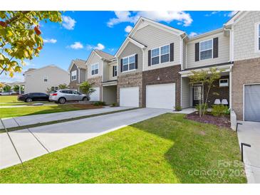 Charming townhomes feature brick accents, attached garages, and manicured lawns at 7004 Everly Commons Ln, Tega Cay, SC 29708