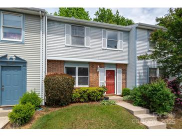 Charming two-story townhome with brick and siding, manicured lawn and a bright red front door at 7309 Pebblestone Dr # D, Charlotte, NC 28212