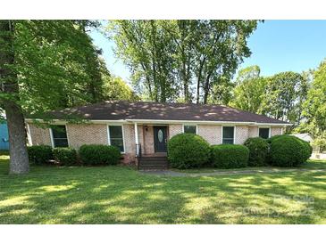 Charming brick home featuring a well-maintained lawn and mature landscaping in a peaceful neighborhood at 7431 Idlewild Rd, Charlotte, NC 28212