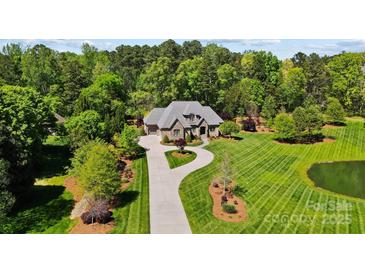 Stunning aerial view of the home with lush landscaping and a circular driveway at 8670 Arbor Oaks Cir, Concord, NC 28027