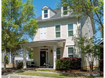 Charming two-story home boasts a cozy front porch, well-kept lawn, and inviting curb appeal at 1424 South St, Cornelius, NC 28031