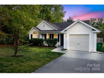 Charming one-story home featuring well-manicured landscaping and an attached garage, set against a colorful twilight sky at 2416 Hart Rd, Charlotte, NC 28214