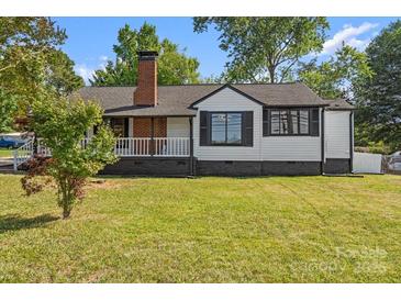 Charming single-story home with a brick chimney and a well-manicured front lawn at 2609 Lowell Rd, Gastonia, NC 28054