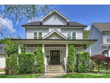 Charming two-story home with a covered front porch, manicured lawn, and lush landscaping at 2841 Attaberry Dr, Charlotte, NC 28205