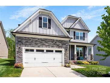 Beautiful two-story home featuring stone accents, a two-car garage, and a welcoming front porch with rocking chairs at 2936 Shumard Dr, Gastonia, NC 28054
