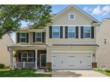 Two-story home with a front porch, two-car garage and a mix of brick, siding, and stone exterior finishes at 314 Pulaski Sw Dr, Concord, NC 28027
