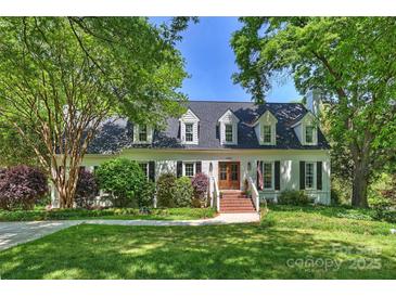 Charming home featuring a manicured lawn and brick entryway, framed by mature trees at 4501 Montibello Dr, Charlotte, NC 28226